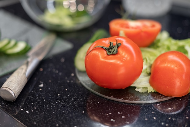 Rode rijpe tomaten op tafel klaar voor salade voorbereiding. gezond veganistisch eten en levensstijl