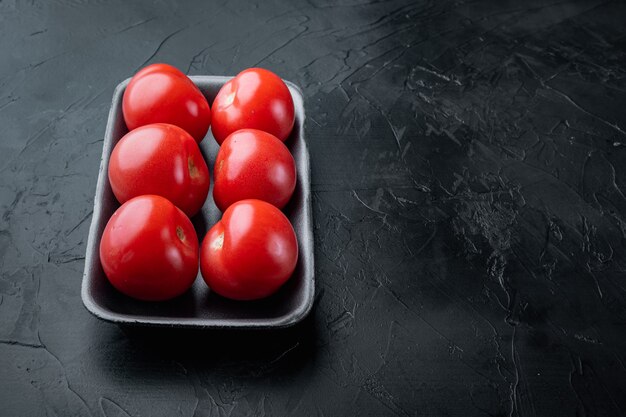 Rode rijpe tomaten, op zwart