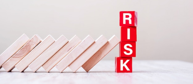 Rode RISK-kubusblokken stoppen vallende blokken op tafel. vallen Bedrijfs-, planning-, management-, oplossing-, verzekerings- en strategieconcepten
