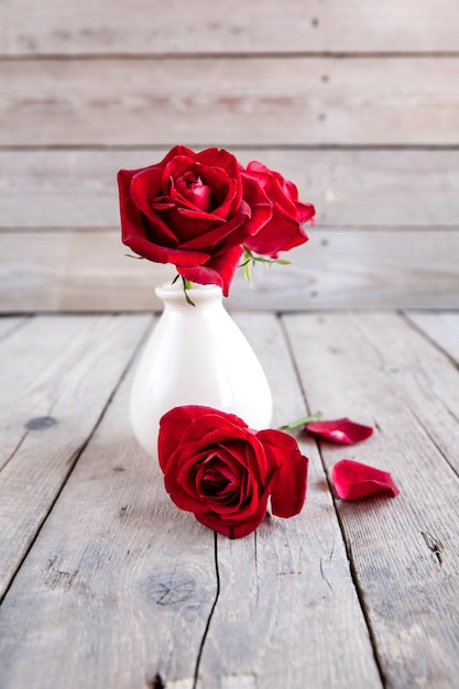 Rode roos in vaas op houten tafel