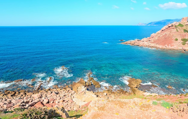 Rode rotsen in de kustlijn van Porticciolo op Sardinië