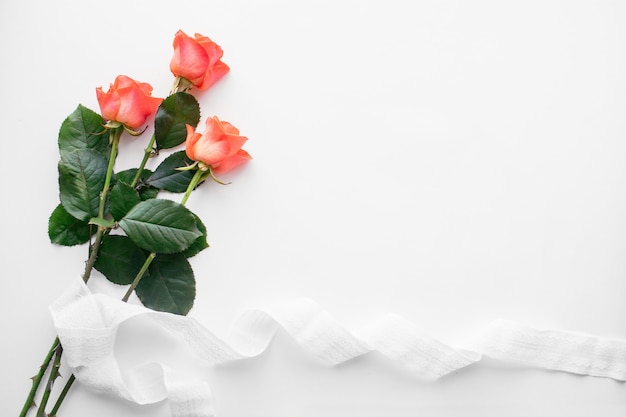 Rode rozen en lint op witte tafel