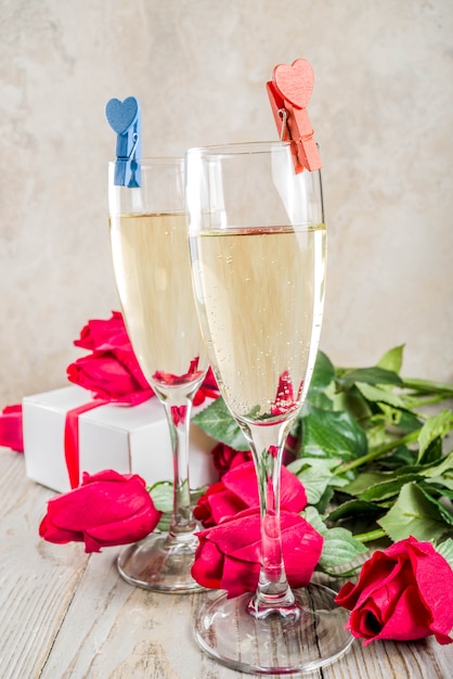 Foto rode rozen met twee champagneglazen