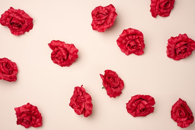 Rode rozenknoppen van textiel op een beige achtergrond, bovenaanzicht