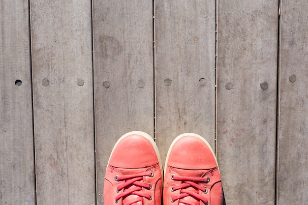 Rode schoenen op een oude houten plank achtergrond