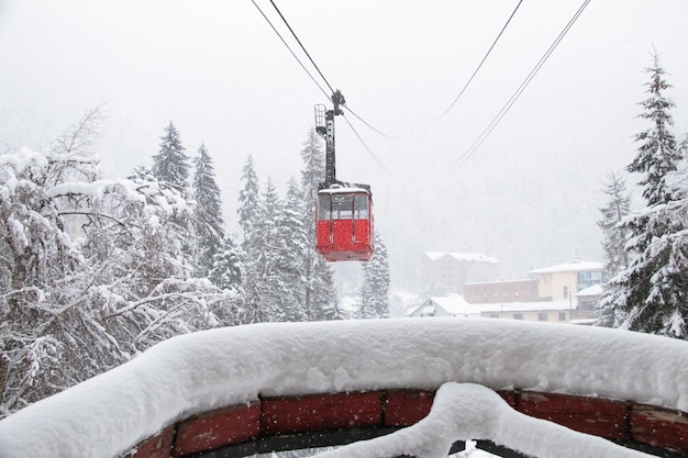 Rode skiliftcabine in de sterke sneeuwval in de bergen van de Kaukasus