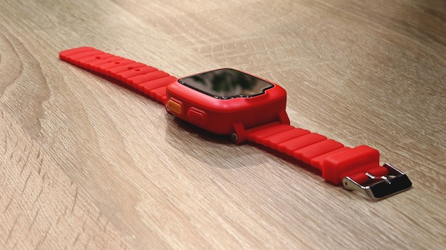 Rode smartwatch voor kinderen op een houten oppervlak