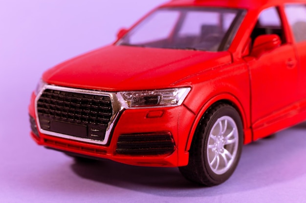 Rode speelgoed automodel voor kinderen geïsoleerd op paarse achtergrond close-up