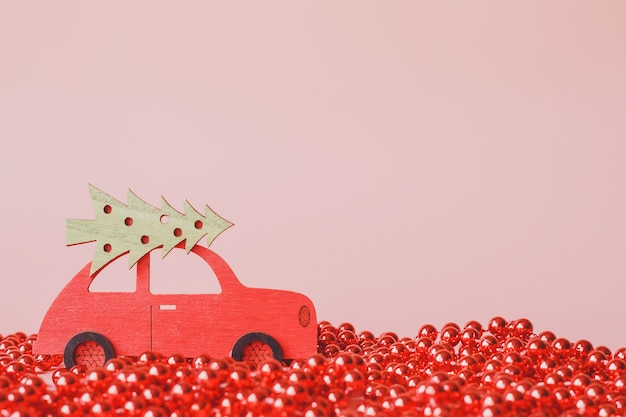 Rode speelgoedauto met kerstboom, op roze