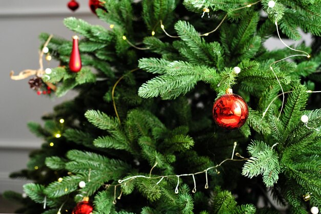 Rode speelgoedballen hangen aan een kerstboom in het interieur van de woonkamer