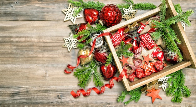 Rode sterren, kerstballen, linten. Kerstversiering, speelgoed en ornamenten met kerstboomtakken. Bovenaanzicht