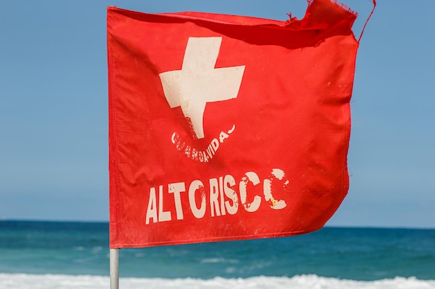 Rode stroomsignaleringsvlag geschreven met hoog risico op een strand in Rio de Janeiro, Brazilië