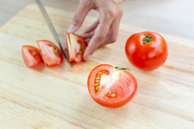 Rode tomaten en plakjes op houten snijplank