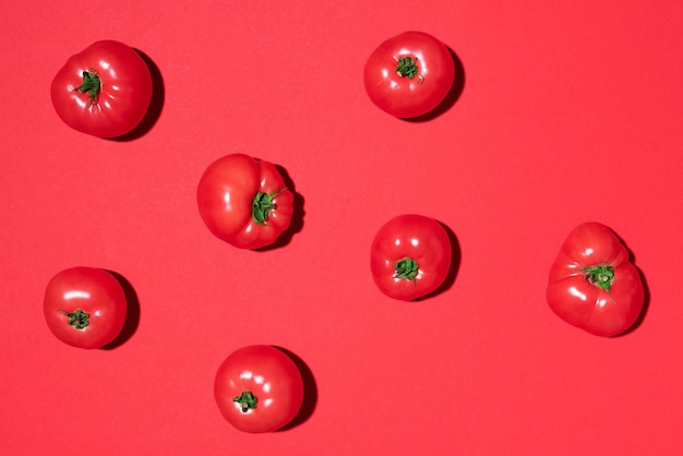 Rode tomaten patroon op rode achtergrond Plat lag bovenaanzicht Zomer minimaal concept Veganistisch en vegetarisch dieet