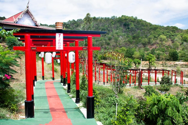 Rode torii-poort van de tempel Wat Khao Sung Chaem Fa op de berg Khao Sam Sip Hap voor Thaise mensen en buitenlandse reizigers reizen bezoek en respect bidden in Tha Maka op 23 mei 2021 Kanchanaburi Thailand