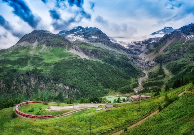 Rode trein Bernina Express naar de doorgang in de bergen.