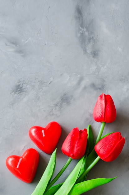 Rode tulpen en kaarsen in de vorm van harten voor Valentijnsdag, dames- of moederdag.