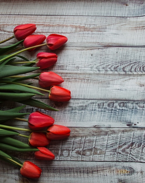 Rode tulpen met bladeren liggen op een houten achtergrond