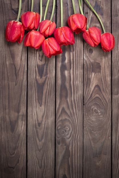 Rode tulpen op donkere houten ondergrond
