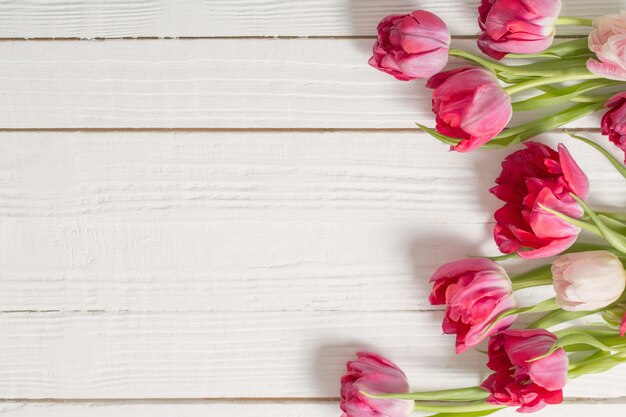 Rode tulpen op witte houten tafel