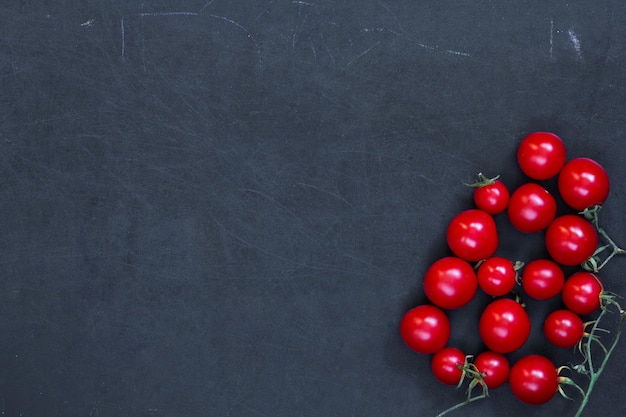 Rode verse tomaten kers op zwarte achtergrond