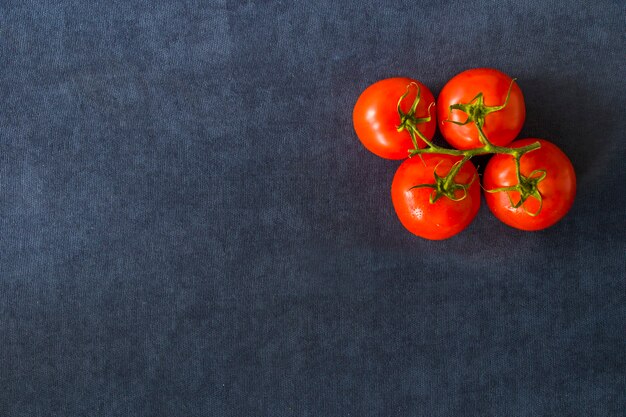 Rode vier tomaten op de blauwe tafel, groente