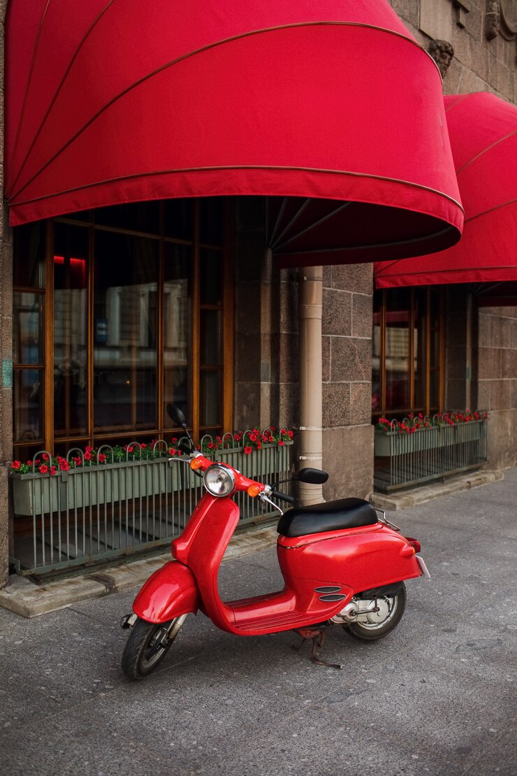 Rode vintage scooter geparkeerd op stoep van lege stad straat.