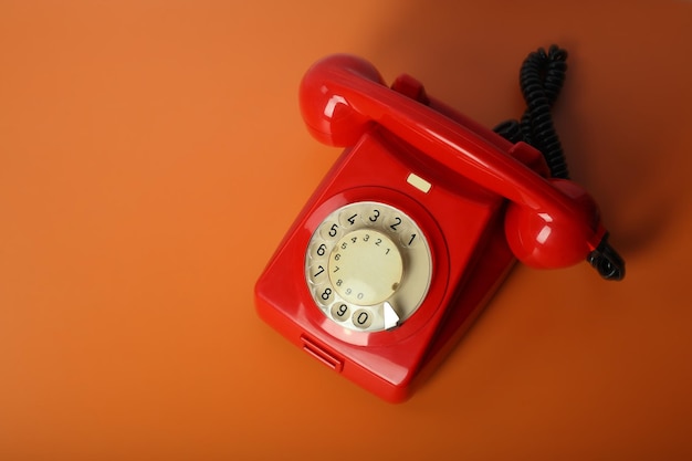 Rode vintage telefoon op een oranje achtergrond