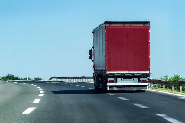 Foto rode vrachtwagen op de snelweg tegen de lucht in de stad