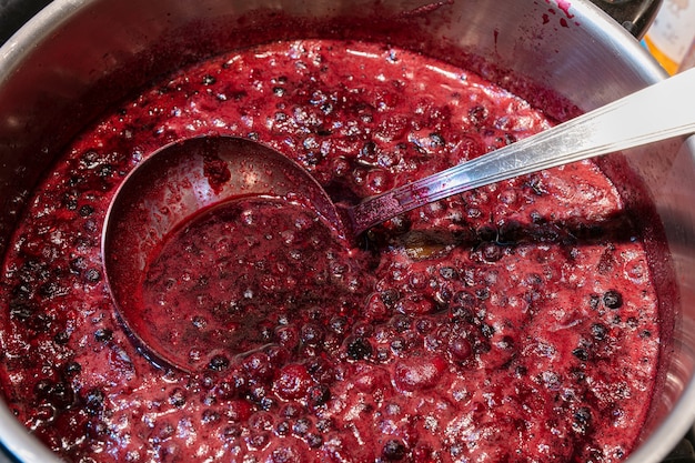 Rode vruchtenjam wordt gekookt in een pan