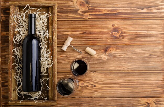 Rode wijn fles kurkentrekker kurken wijnglazen op houten tafel met kopie ruimte. Rode wijn samenstelling op bruin houten tafel. Bovenaanzicht.