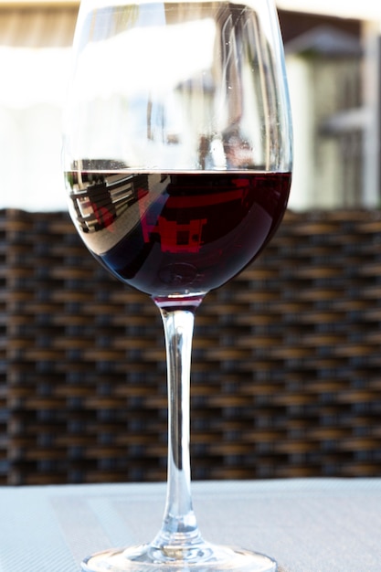 Rode wijn in een groot glas op tafel in een zomercafé op de veranda