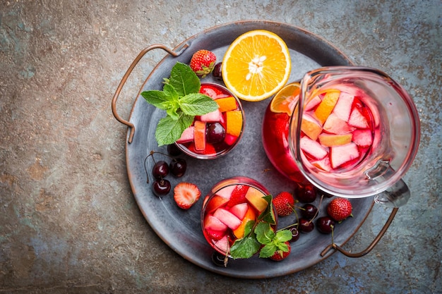 Rode wijn sangria of punch met fruit en ijs in glazen bovenaanzicht. Huisgemaakte verfrissende fruitsangria.