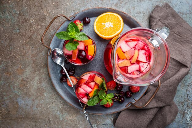 Rode wijn sangria of punch met fruit en ijs in glazen bovenaanzicht. Huisgemaakte verfrissende fruitsangria.