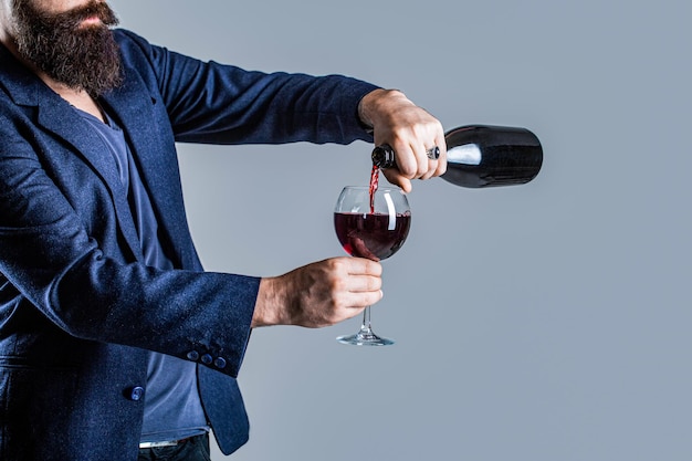 Rode wijn uit de fles in het wijnglas Gieter rode wijn in een glas Sommelier man degustator wijnmaker mannelijke wijnmaker Bottel rode wijn glas