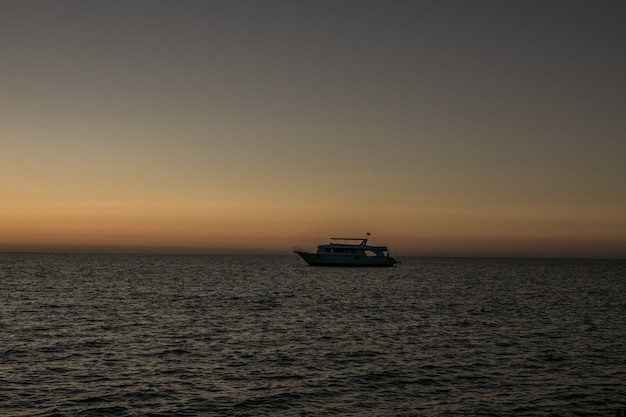 Rode zonsopganghemel op zee en silhouetten van schepen die op zee varen