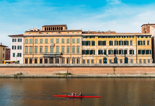 Roeiers op de rivier de Arno in Pisa, Toscane, Italië met prachtige kleurrijke Italiaanse architectuur op de achtergrond