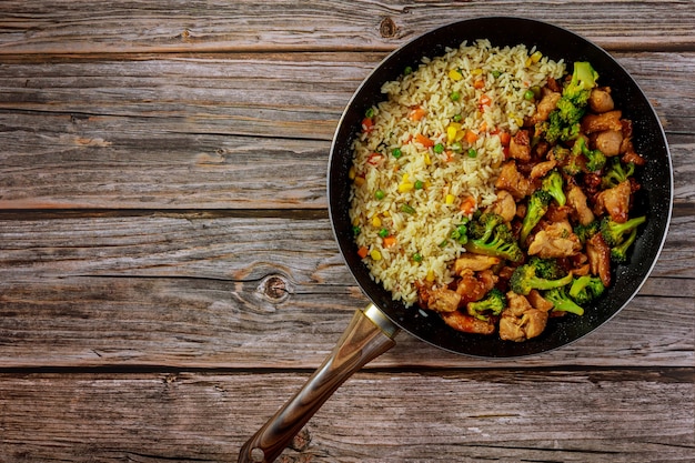 Roerbak kip met broccoli in zoetzure saus en rijst. Aziatische maaltijd.