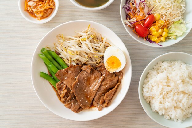 Roerbak Teriyaki-varkensvlees met sesamzaadjes, taugé, gekookt ei en rijstset - Japans eten