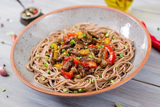 Roerbak uit kippenharten, paprika, uien en boekweitnoedels.