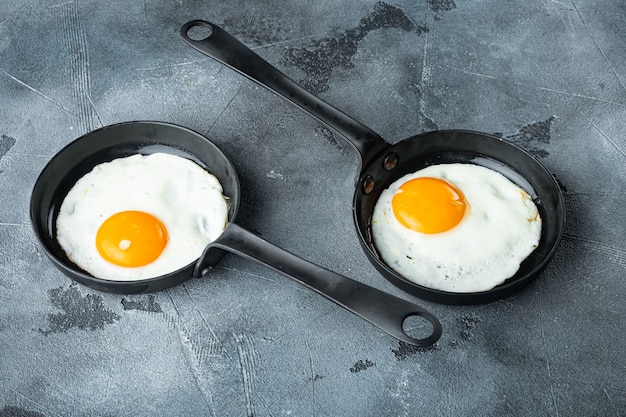 Roerei in koekenpan met varkensreuzel, brood en groene veren in gietijzeren koekenpan