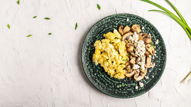 Roerei met champignons en cottage cheese. heerlijk ontbijt of tussendoortje op een lichte tafel, bovenaanzicht.