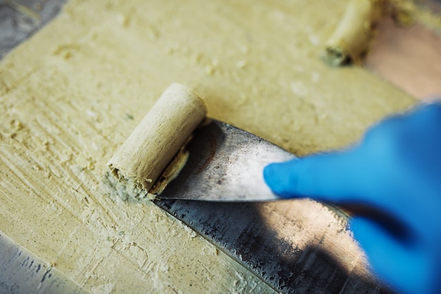 Roergebakken ijs rolt bij vriespan. Met de hand gemaakt gerold roomijsdessert op koude plaat. Gebakken ijsmachine met stalen gekoelde pan.