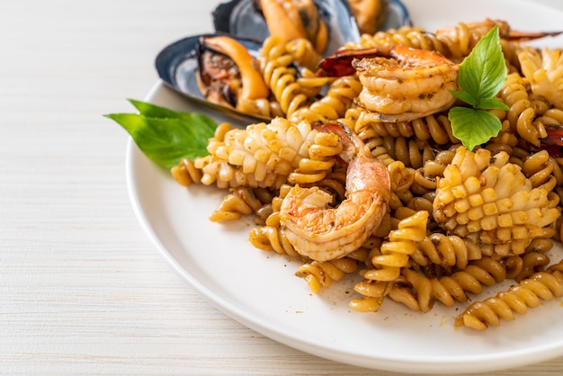 roergebakken spiraalvormige pasta met zeevruchten en basilicumsaus - fusion food-stijl