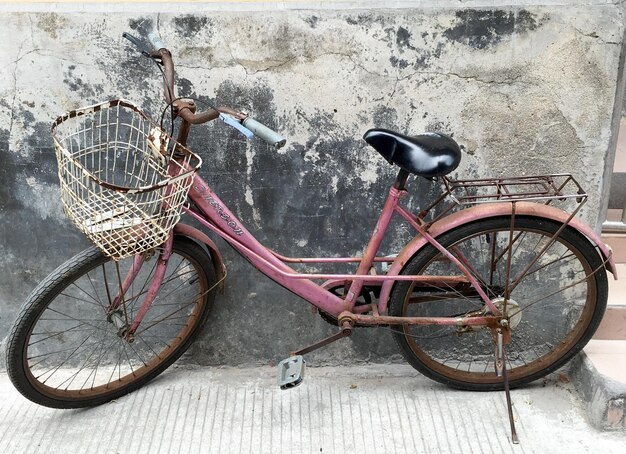 Foto roestige fiets geparkeerd tegen de muur