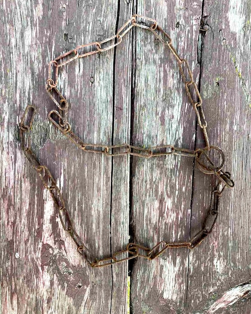 Roestige ketting. Roestige kettingschakels op een achtergrond van oud hout.