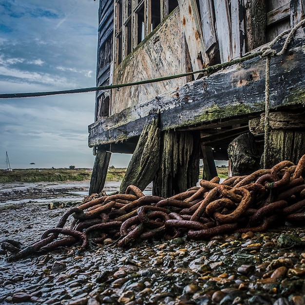 Roestige metalen structuur op het strand tegen de lucht