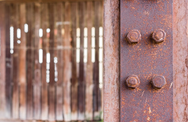 Roestige moer en bout met de metalen plaat waren bevestigd aan een plakkerig stuk hout op de houten muur