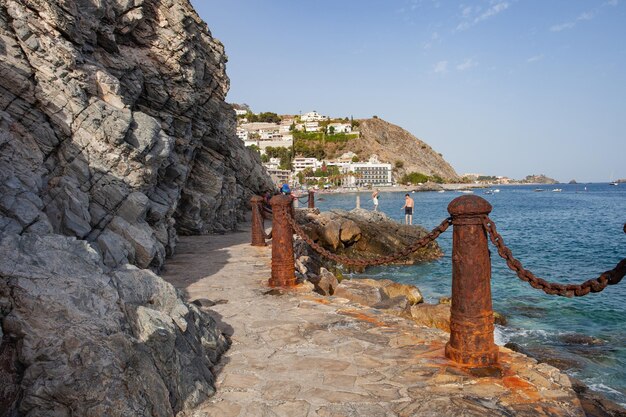 roestige palen en kettingen op het strand van Cotobro, aan de kust van Granada