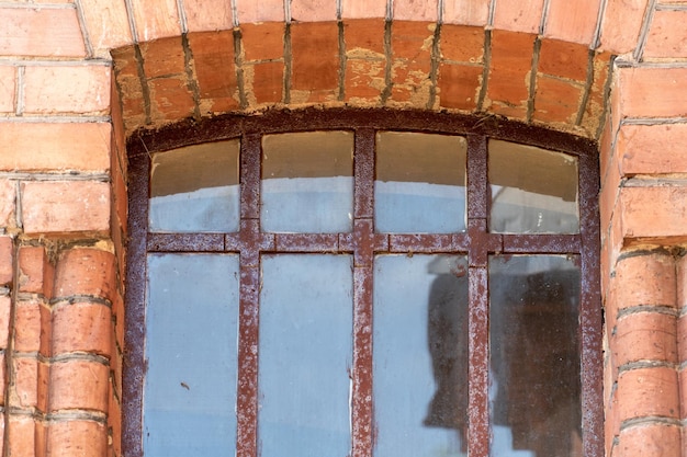 Roestige tralies voor de ramen van oude antieke gebouwen Historische en culturele waarden Rode bakstenen muur Restauratie van een kasteel of gevangenis